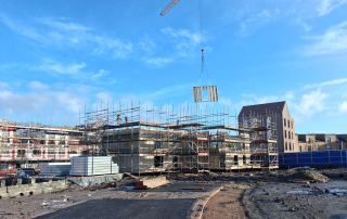 A photo of a self erecting tower crane lifting a light gauge steel frame panel